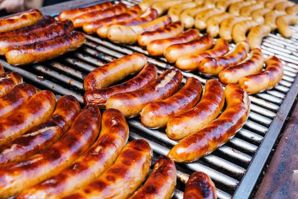 stock image Grilled German sausages, golden on the fire.