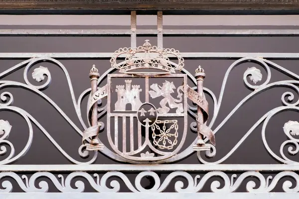 Shield of the kingdom of Spain, on a metal fence, with the motto Plus Ultra, in Latin 
