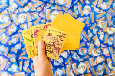 Valencia, Spain - January 10, 2023: A single boy male hand holds a pokemon trading card game.