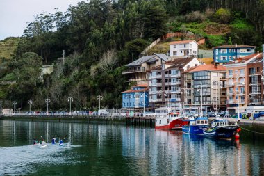 Ribadesella, Spain - March 31, 2024: Canoeists training in the waters of the seaport of Ribadesella. clipart