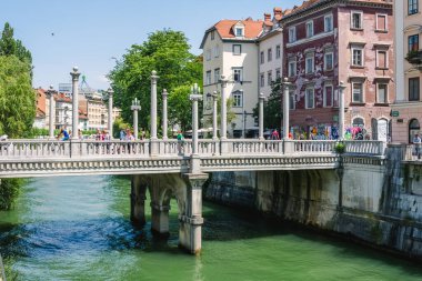 Turistler, Slovenya 'nın Ljubljana kentindeki Cobblers Köprüsü yakınlarında dolaşıyorlar.