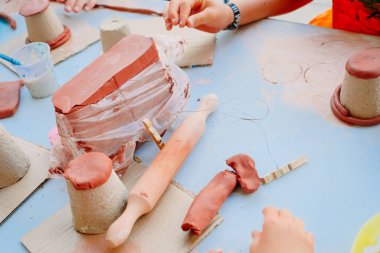 Çocuklar el sanatları dersinde çömlek tekniklerini öğrenirler, killeri değişik şekillerde şekillendirirler..
