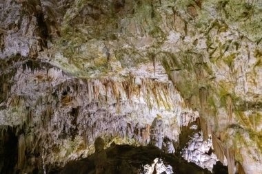 Gözlerden uzak bir yeraltı mağarasında doğal ışıklandırmayla nefes kesici sarkıt oluşumlarını keşfedin..