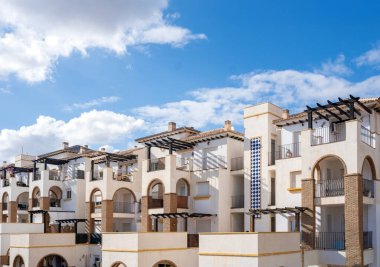 Akdeniz tarzı modern turistik daireler parlak gökyüzüne karşı kurulmuş, İspanya 'da büyüleyici bir tatil deneyimi sunuyor.