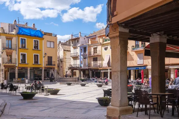 San Mateu, İspanya - 22 Mart 2025: Sant Mateu, Castellon 'da güneşli plaza canlı mimari ve canlı açık havada oturma