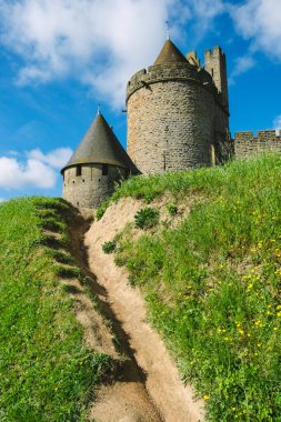 Castillo de Carcassonne 'un cazibesini yaşayın. Etkileyici kuleleri olan tarihi bir kale. Parlak yeşil ve mavi gökyüzüne karşı kurulmuş..