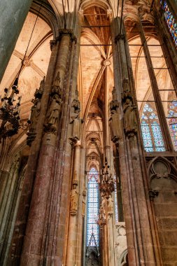 Carcassonne Katedrali 'nin nefes kesici iç kısımlarını keşfedin. Karmaşık oymalarla süslenmiş sütunlar ve kutsal mekanı aydınlatan renkli vitraylı pencereler..