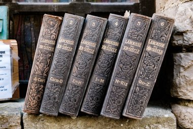 Toulouse, Fransa - 21 Nisan 2025: Vintage Larousse Sözlükleri büyüleyici bir antika dükkanının ahşap rafında dizilmiş