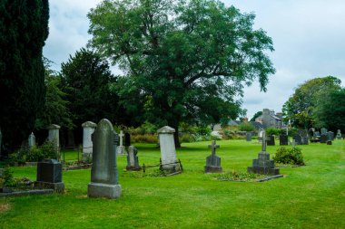 Bu dingin İrlanda mezarlığında yemyeşil çimenler ve terk edilmiş eski mezar taşları, huzurlu ve tarihsel bir yerde bir huzur ve yansıma hissi uyandırıyor..