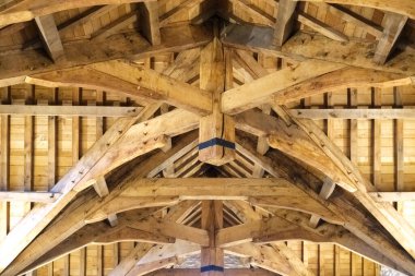 Sanatçılar özenle inşa edilmiş bir iç çatıya ahşap kirişler döşüyorlar, karmaşık tasarımlar sergiliyorlar ve sıcak ışıklandırma altında uzman işçiliği sergiliyorlar..