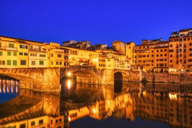 Ponte Vecchio Köprüsü 'nü Dusk, Floransa, İtalya' daki Arno Nehri Yansıması ile aydınlatmış. 