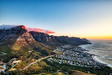 Cape Town Günbatımı Kamp Koyu Sahili üzerinde Masa Dağı ve Arka planda 12 Havari, Güney Afrika  