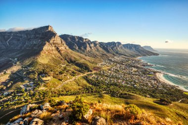 Güneşli bir günde Cape Town 'da Kamp Koyu Sahili' ne bakan Masa Dağı ve Güney Afrika 'da On İki Havari