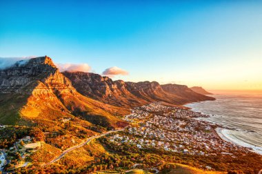 Cape Town Günbatımı Kamp Koyu Sahili üzerinde Masa Dağı ve Arka planda 12 Havari, Güney Afrika 