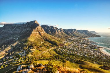 Güneşli bir günde Cape Town 'da Kamp Koyu Sahili' ne bakan Masa Dağı ve Güney Afrika 'da On İki Havari