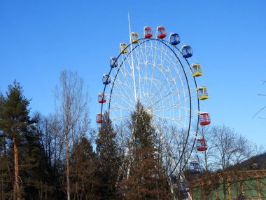 Parkta kırmızı, sarı, mavi kamaralı feribot çarkı