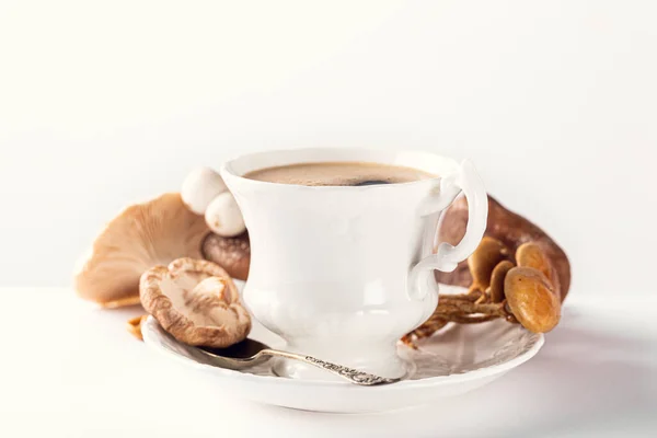 White porcelain vintage cup with mushroom coffee on white background. New Superfood Trend, selective focus and copy space