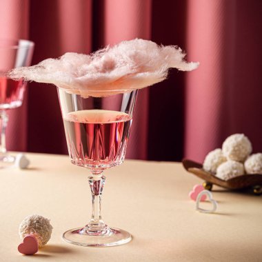 Romantic composition with Valentines day beverage, glasses with tasty cotton candy champagne on pink background with copy space
