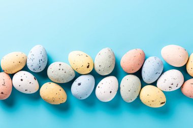 Overhead shot of Easter quail eggs over blue background. Spring holidays concept with copy space. Top view
