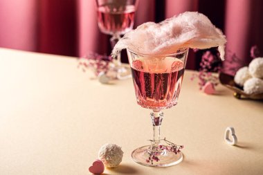 Romantic composition with Valentines day beverage, glasses with tasty cotton candy champagne on pink background with copy space