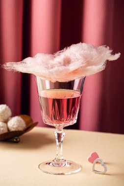 Romantic composition with Valentines day beverage, glasses with tasty cotton candy champagne on pink background with copy space