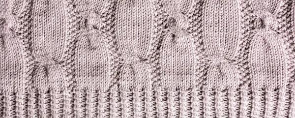 編組ケーブル付きグレーベージュウールセーターを編む背景 頭上のショットバナーの上 — ストック写真
