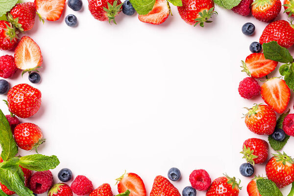 Ягодный фон с клубникой, малиной и черникой поверх белого, вид сверху, плоский уголок. Creative food concept with copy space