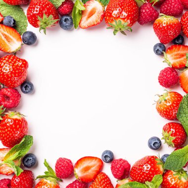 Beyaz arka planda taze çilek, ahududu ve yaban mersininden yapılmış çerçeve, üst manzara, düz yatak. Fotokopi alanı olan sağlıklı gıda kavramı