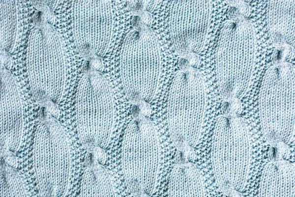 ケーブルが付いているセーターのためのターコイズ編みパターンが付いている背景 オーバーヘッドショット — ストック写真