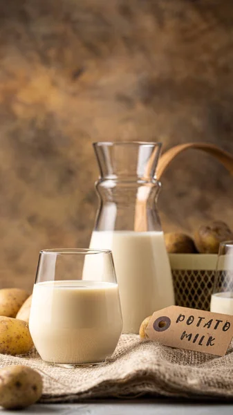 透明玻璃杯中的植物乳 可供选择的土豆牛奶和马铃薯块茎在麻布上 健康的素食主义者和素食主义者的饮酒概念与复制空间 电话壁纸的智能手机格式 — 图库照片
