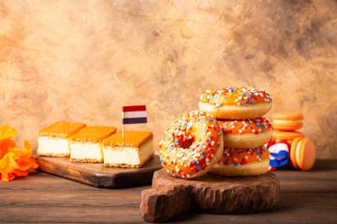 Etkinlik Kralları Günü için portakallı Hollanda tatlıları tompouce ve donutları. Ulusal Bayram Koningsdag 27 Nisan 'da Hollanda' da. Kopya alanı ile Hollanda kültürü kavramı