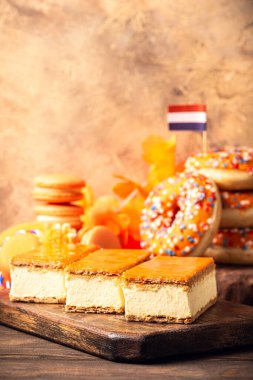 Arka planda Hollanda Etkinlik Kralları Günü olan portakallı tompouce ve donut tatlısı. Ulusal Bayram Koningsdag 27 Nisan 'da Hollanda' da. Kopya alanı ile Hollanda kültürü kavramı
