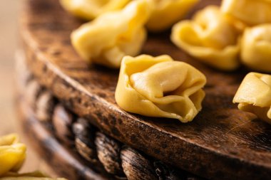 Yakın plan tortellini Cappelletti makarna prosciutto ile, kırsal ahşap tahta üzerinde mükemmel düzenlenmiş fotokopi alanı ile