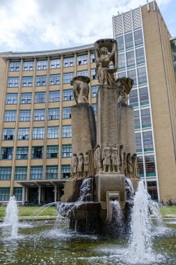 Eindhoven, Hollanda - 28 Haziran 2025: Philips fontein Panta Rhei çeşmesi modern mimari Philips Bedrijfsschool 'a karşı akan su ve karmaşık heykeller içerir