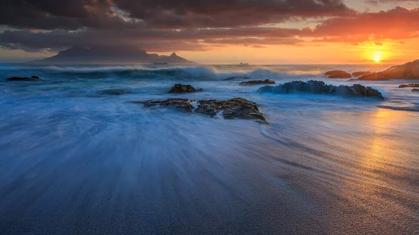 Stürmischer Dezember Sonnenuntergang Mit Tafelberg Wellen Zeitlupe Vom Bloubergstrand Stockbild