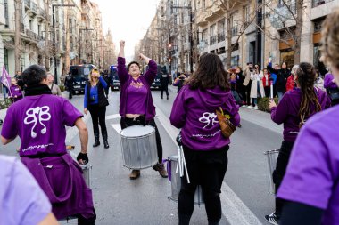Mor giyinmiş bir grup insan, İspanya 'nın Granada kentinin sokaklarında düzenlenen Uluslararası Kadın Günü gösterisinde batucada' yı davullarla protesto ediyorlar.