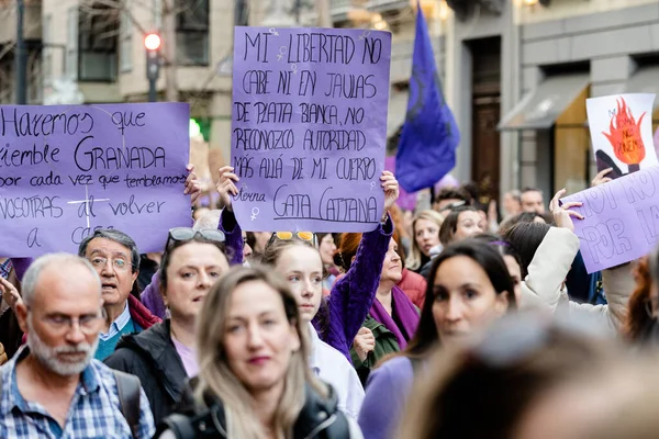 Stock image People holding posters with protest messages during the International Womens Day demonstration through the streets of Granada, Spain