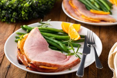 Noel ballı, portakallı jambon yeşil fasulyeli bir tabakta servis edilir.