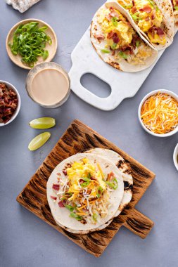 Peynirli ve yeşil soğanlı çırpılmış yumurta ve jambonlu kahvaltılık taco yapıyorum.