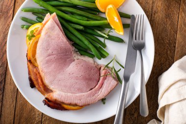 Noel ballı, portakallı jambon yeşil fasulyeli bir tabakta servis edilir.