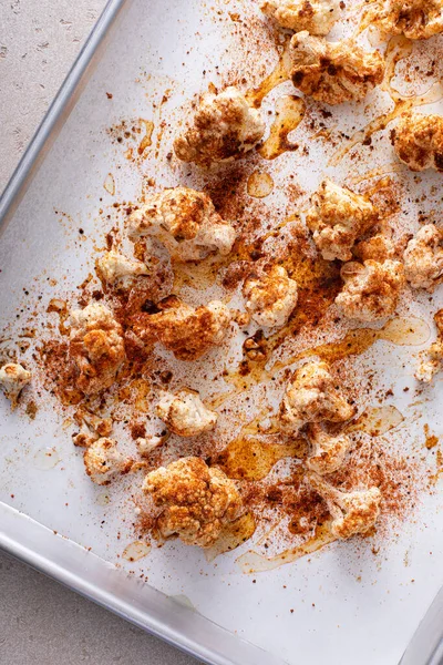 Making roasted cauliflower on a sheet pan with paprika and spices, top view