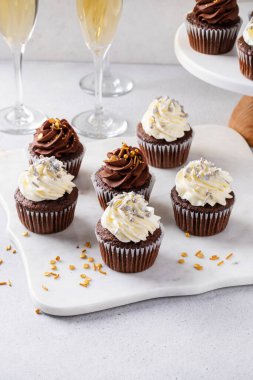 Yeni yıl partisi için şampanyayla servis edilen şekerli kekler, tatlı fikri.