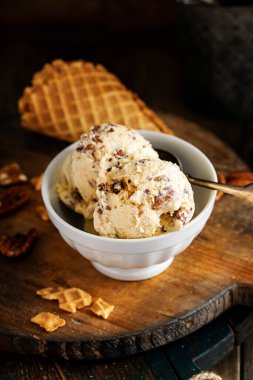 Tereyağlı cevizli dondurma, kırsal alanda beyaz bir kasede.