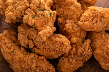 Kızarmış tavuk kızartması ya da ketçap ve patates kızartması ile yakın servis edilir.