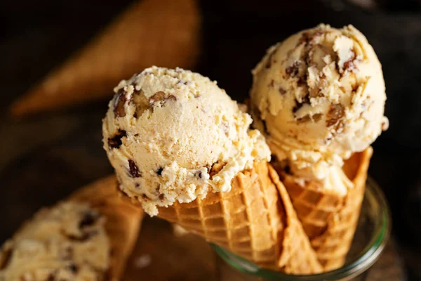 Butter pecan ice cream in waffle cones in rustic setting