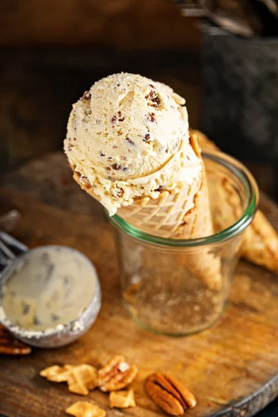 Butter pecan ice cream in waffle cones in rustic setting