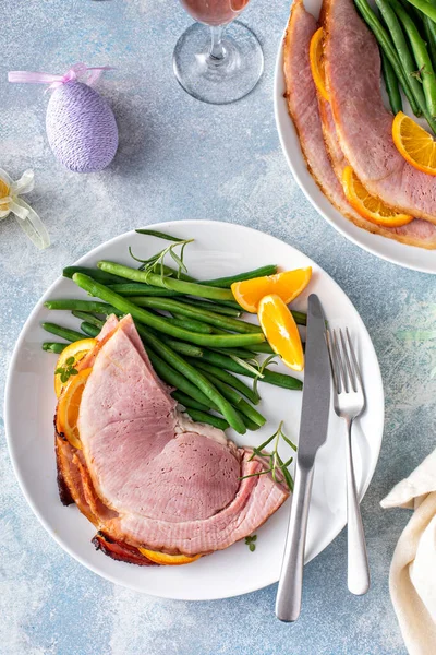 Easter spiral sliced glazed ham served on a plate with green beans