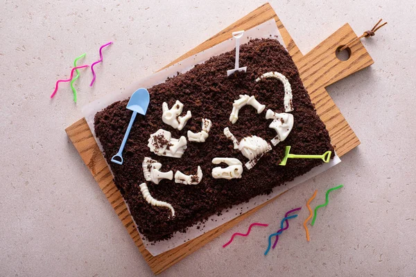 Chocolate cake with dinosaur bones for a child birthday, themed birthdy cake idea