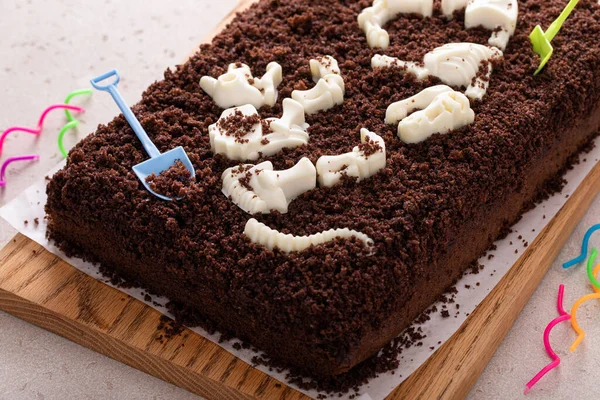 Chocolate cake with dinosaur bones for a child birthday, themed birthdy cake idea