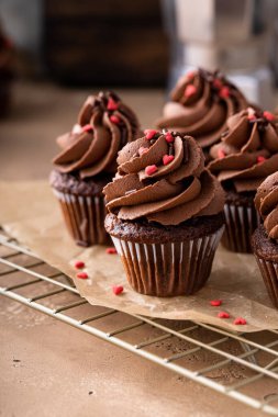 Dark chocolate mini cupcakes with chocolate ganache frosting and heart sprinkles for Valentines day